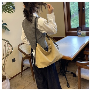 Vue détaillée d'un grand sac hobo en toile beige avec des anses en corde noire au café