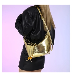 Detalle del bolso de media luna dorado con elegantes cuentas de ámbar y textura fina