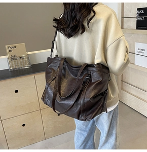 Close-up of vintage brown tote bag with retro oil wax texture and wide shoulder strap