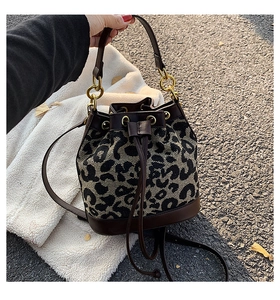 Detail of leopard print bucket bag with drawstring closure and golden hardware
