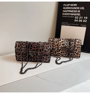 Détail de sacs à motif léopard avec rivets noirs et bandoulières en chaîne métal