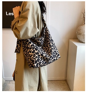Detailed view of the large capacity leopard print canvas tote bag on a model shoulder