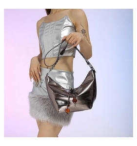 Detalle de bolso acolchado plateado con cordón de cuentas ámbar y acabado metálico