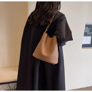 Détail du fond de sac seau en cuir marron avec clous de protection en métal doré