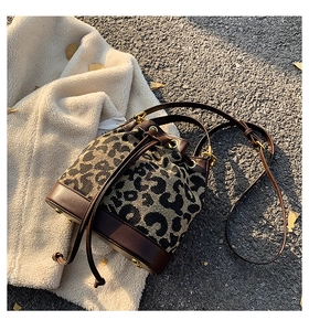 Close-up of leopard print bucket bag featuring leather drawstring and gold metal hardware