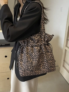 Chic leopard print canvas tote bag with drawstring closure and practical front pocket