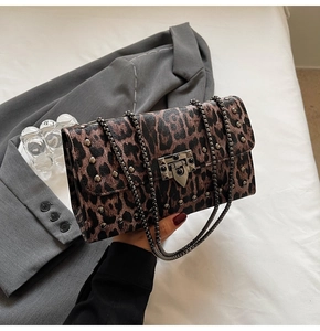 Vue détaillée du sac léopard avec texture grainée, rivets métalliques et chaîne dorée