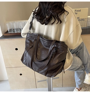 Detail of vintage brown tote bag with retro wrinkled texture and adjustable strap