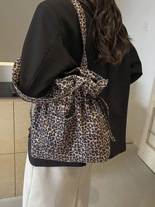 Leopard print canvas bucket bag with drawstring closure and adjustable shoulder strap