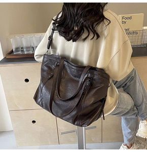 Detail view of the deep brown large tote bag with star rivets and adjustable straps
