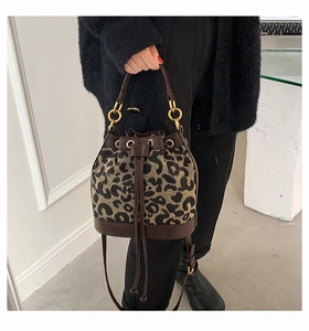 Detailed view of leopard print bucket bag with drawstring closure and golden hardware