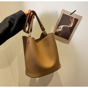 Détail du grand sac seau marron en cuir à motif litchi avec boucle en métal doré mat