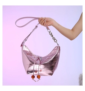 Detalle del bolso hobo rosa metalizado con cadena plateada y colgantes de cuentas de ámbar