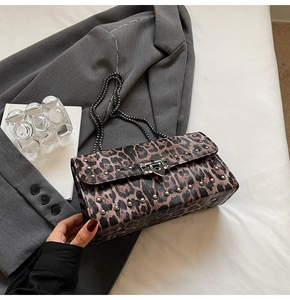 Détail du sac à rabat imprimé léopard avec clous argentés et fermoir rotatif en métal