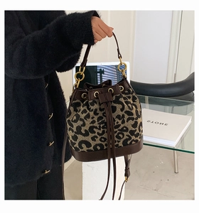 Detailed close-up of a leopard print bucket bag with drawstring and golden metal rings