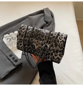 Détail du sac à bandoulière léopard avec des rivets sombres et une bandoulière chaîne