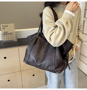 Detail of deep brown tote bag featuring vintage oil-wax leather texture and shoulder strap