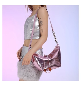 Detalle del bolso de hombro media luna rosa metalizado con cadena y textura acolchada