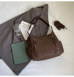 Detail of dark coffee litchi grain leather tote with dual silver zippers and extra strap