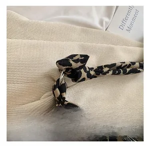 Detailed close-up of leopard print canvas fabric with a durable metallic ring connector