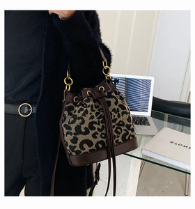 Detail of leopard print bucket bag with brown leather drawstring and gold metal rings