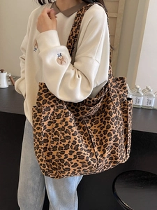Large leopard print canvas tote bag with side pockets shown in a stylish casual setting