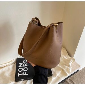 Détails du sac seau en cuir grainé marron foncé avec boucle dorée et bandoulière large