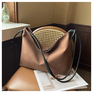 Détail du sac hobo en toile marron avec bandoulière noire nouée sur cuir