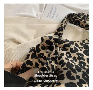Detail of metal ring hardware and adjustable strap on leopard print canvas bag