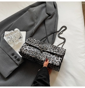 Détail du sac léopard gris avec clous métalliques et bandoulière chaîne noire