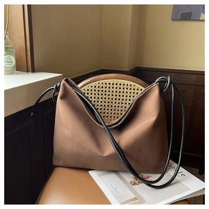 Détail du sac cabas marron avec des bretelles en corde noire nouées de style minimaliste