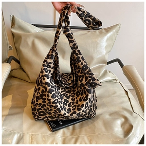 Detail of leopard print canvas tote bag featuring a stylish knotted shoulder strap design