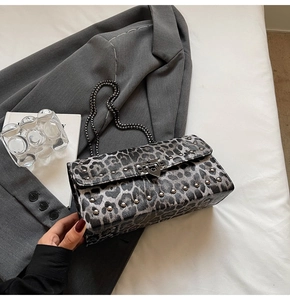 Détail du sac baguette à imprimé léopard avec rivets en métal et bandoulière chaîne