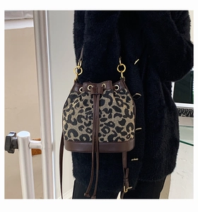 Detail of leopard print bucket bag with brown leather trim and gold hardware