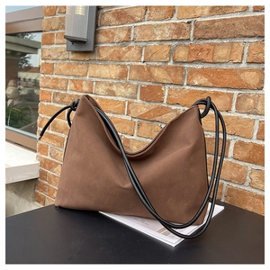 Détail du cabas en daim marron avec bandoulière élégante en corde nouée de couleur noire