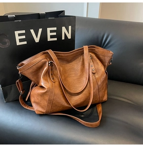 Detail of brown faux leather tote with star metal rivets and textured litchi grain