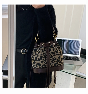 Fashionable leopard print bucket bag with drawstring detail shown in an office setting