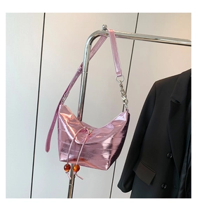 Detalle de bolso hobo rosa metalizado con cadena plateada y cuentas ámbar decorativas