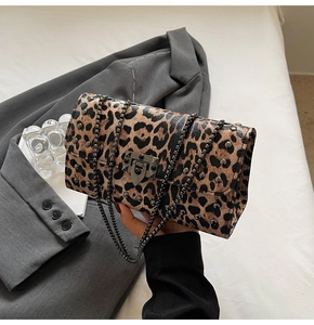 Détail du sac léopard avec rivets en métal bronze et bandoulière en chaîne chic