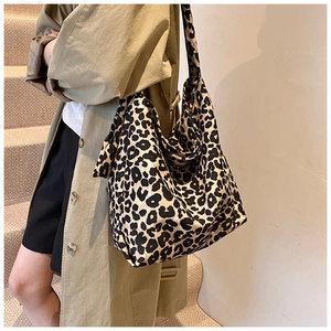 Detail of trendy leopard print canvas crossbody bag showing large capacity and strap