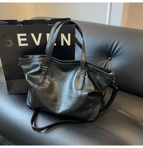 Detail of black faux leather tote bag with star rivets and adjustable shoulder strap