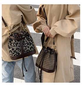 Detail of drawstring bucket bags in leopard print and houndstooth with gold hardware