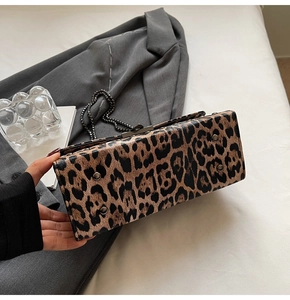Détail du sac à main léopard montrant les pieds de protection en métal et la bandoulière