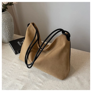 Détail du sac en daim marron avec poignées en corde noire et attaches à anneaux métalliques