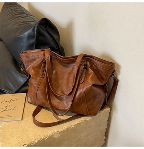 Detail of vintage brown tote bag with star rivets and adjustable shoulder strap texture