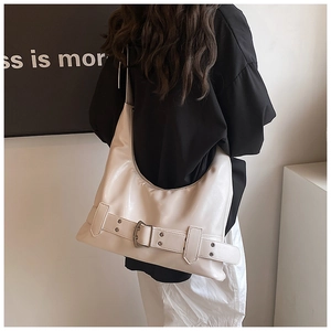 Detail of a large cream-white leather Hobo bag with a buckle strap and a glossy finish
