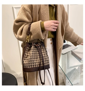 Houndstooth drawstring bucket bag with leather strap and chain handle shown on model
