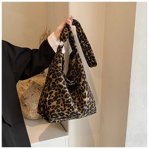 Detail of trendy leopard print canvas tote bag with wide strap in minimalist indoor setting