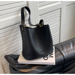 Détail du sac seau en cuir grainé noir avec des finitions métalliques dorées élégantes