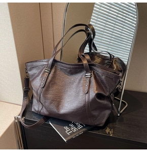 Detail of dark brown tote bag featuring vintage leather and silver star rivet accents